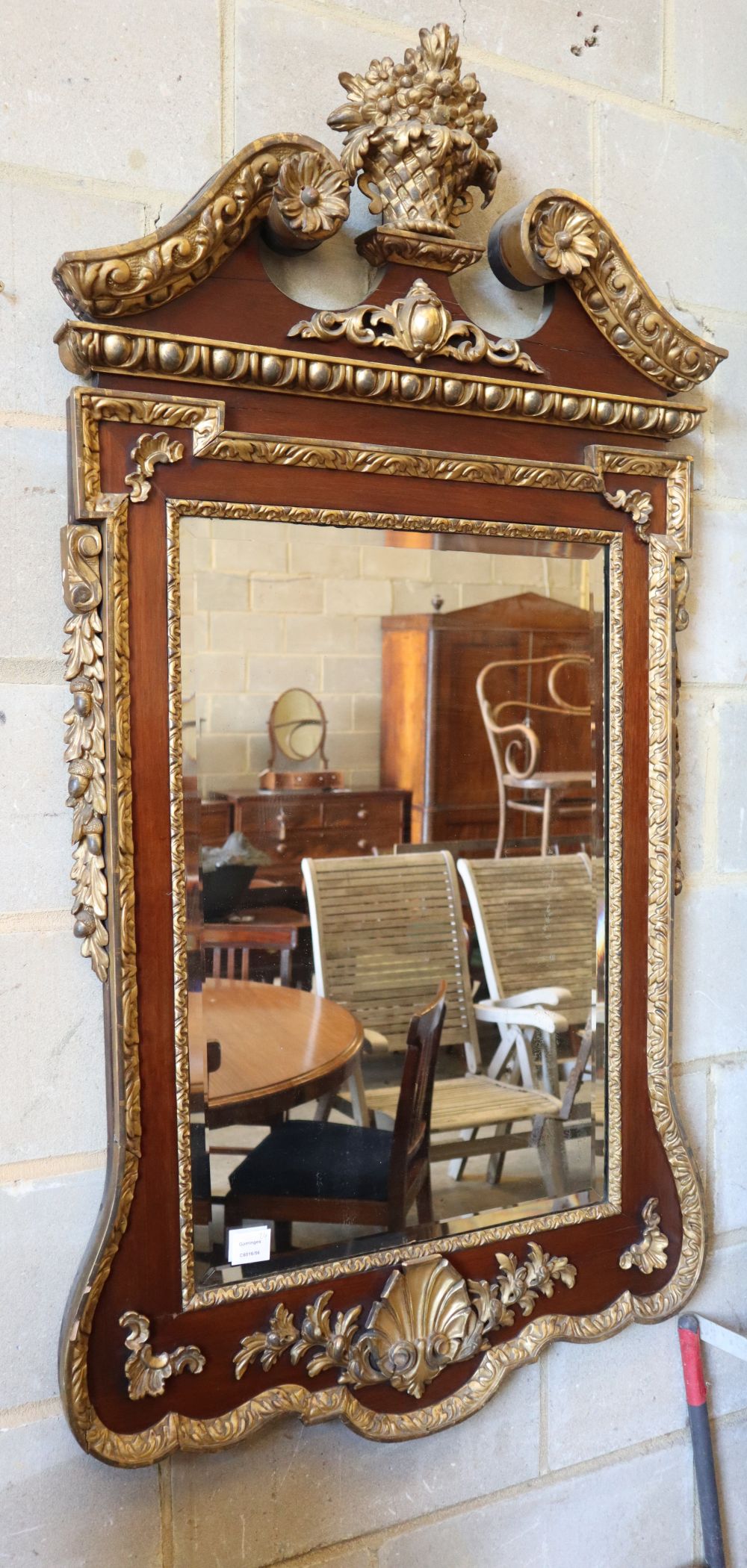 An 18th century style parcel gilt mahogany wall mirror in the manner of William Kent, W.74cm, H.142cm